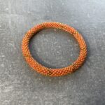 Unikke håndlavet nepal armbånd af glasperler- Som er knyttet perle for perle – Af Nepalesiske Kvinder.  Kvindegrupper i Nepal, Kathmandu Valley, udstyres med glasperler og bomuldsgarn, så de i deres fritid kan håndknytte de smukke perlearmbånd. Hvert armbånd er et unikt resultat af kvindernes håndarbejde og varierer i farvekombinationer og mønstre. De er hæklet med en bomuldssnor. Syntes man at de lidt stramme, kan man vride forsigtigt i dem så de bliver større. syntes man derimod at de er blive lidt for løse, kan man ligge dem i vand. dette gør at bomuldssnoren trækker sig sammen og de bliver mindre igen. Unikke håndlavet nepal armbånd, som er knyttet perle for perle, af nepalesiske kvinder. Vi har mere end 200 forskellige, at vælge i mellem. Så du kan finde de helt rigtige roll on nepal perle armbånd.