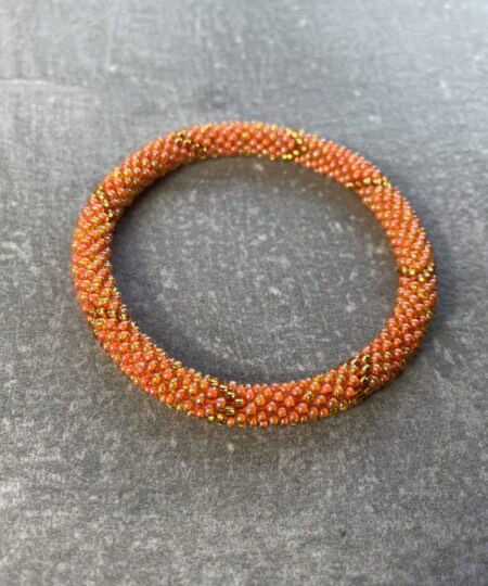 Unikke håndlavet nepal armbånd af glasperler- Som er knyttet perle for perle – Af Nepalesiske Kvinder.  Kvindegrupper i Nepal, Kathmandu Valley, udstyres med glasperler og bomuldsgarn, så de i deres fritid kan håndknytte de smukke perlearmbånd. Hvert armbånd er et unikt resultat af kvindernes håndarbejde og varierer i farvekombinationer og mønstre. De er hæklet med en bomuldssnor. Syntes man at de lidt stramme, kan man vride forsigtigt i dem så de bliver større. syntes man derimod at de er blive lidt for løse, kan man ligge dem i vand. dette gør at bomuldssnoren trækker sig sammen og de bliver mindre igen. Unikke håndlavet nepal armbånd, som er knyttet perle for perle, af nepalesiske kvinder. Vi har mere end 200 forskellige, at vælge i mellem. Så du kan finde de helt rigtige roll on nepal perle armbånd.