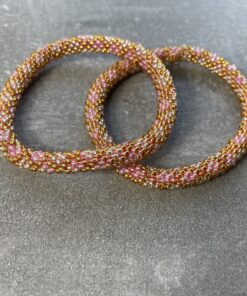 Unikke håndlavet nepal armbånd af glasperler- Som er knyttet perle for perle – Af Nepalesiske Kvinder. Kvindegrupper i Nepal, Kathmandu Valley, udstyres med glasperler og bomuldsgarn, så de i deres fritid kan håndknytte de smukke perlearmbånd. Hvert armbånd er et unikt resultat af kvindernes håndarbejde og varierer i farvekombinationer og mønstre. De er hæklet med en bomuldssnor. Syntes man at de lidt stramme, kan man vride forsigtigt i dem så de bliver større. syntes man derimod at de er blive lidt for løse, kan man ligge dem i vand. dette gør at bomuldssnoren trækker sig sammen og de bliver mindre igen. Unikke håndlavet nepal armbånd, som er knyttet perle for perle, af nepalesiske kvinder. Vi har mere end 200 forskellige, at vælge i mellem. Så du kan finde de helt rigtige roll on nepal perle armbånd.