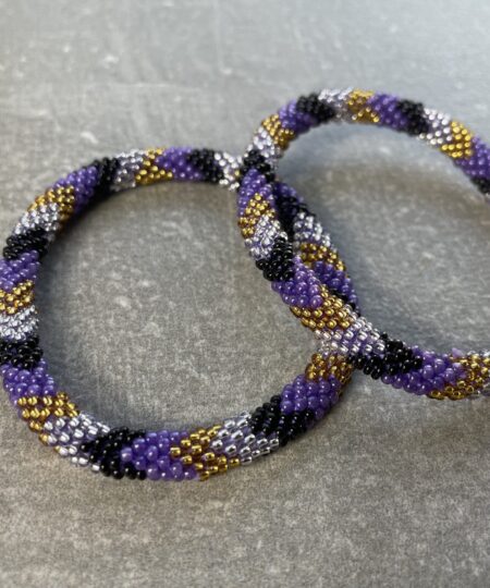 Unikke håndlavet nepal armbånd af glasperler- Som er knyttet perle for perle – Af Nepalesiske Kvinder.  Kvindegrupper i Nepal, Kathmandu Valley, udstyres med glasperler og bomuldsgarn, så de i deres fritid kan håndknytte de smukke perlearmbånd. Hvert armbånd er et unikt resultat af kvindernes håndarbejde og varierer i farvekombinationer og mønstre. De er hæklet med en bomuldssnor. Syntes man at de lidt stramme, kan man vride forsigtigt i dem så de bliver større. syntes man derimod at de er blive lidt for løse, kan man ligge dem i vand. dette gør at bomuldssnoren trækker sig sammen og de bliver mindre igen. Unikke håndlavet nepal armbånd, som er knyttet perle for perle, af nepalesiske kvinder. Vi har mere end 200 forskellige, at vælge i mellem. Så du kan finde de helt rigtige roll on nepal perle armbånd.