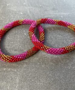 Unikke håndlavet nepal armbånd af glasperler- Som er knyttet perle for perle – Af Nepalesiske Kvinder.  Kvindegrupper i Nepal, Kathmandu Valley, udstyres med glasperler og bomuldsgarn, så de i deres fritid kan håndknytte de smukke perlearmbånd. Hvert armbånd er et unikt resultat af kvindernes håndarbejde og varierer i farvekombinationer og mønstre. De er hæklet med en bomuldssnor. Syntes man at de lidt stramme, kan man vride forsigtigt i dem så de bliver større. syntes man derimod at de er blive lidt for løse, kan man ligge dem i vand. dette gør at bomuldssnoren trækker sig sammen og de bliver mindre igen. Unikke håndlavet nepal armbånd, som er knyttet perle for perle, af nepalesiske kvinder. Vi har mere end 200 forskellige, at vælge i mellem. Så du kan finde de helt rigtige roll on nepal perle armbånd.