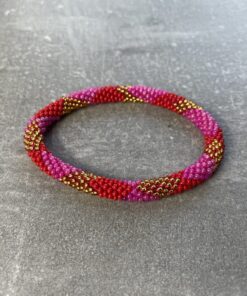 Unikke håndlavet nepal armbånd af glasperler- Som er knyttet perle for perle – Af Nepalesiske Kvinder. Kvindegrupper i Nepal, Kathmandu Valley, udstyres med glasperler og bomuldsgarn, så de i deres fritid kan håndknytte de smukke perlearmbånd. Hvert armbånd er et unikt resultat af kvindernes håndarbejde og varierer i farvekombinationer og mønstre. De er hæklet med en bomuldssnor. Syntes man at de lidt stramme, kan man vride forsigtigt i dem så de bliver større. syntes man derimod at de er blive lidt for løse, kan man ligge dem i vand. dette gør at bomuldssnoren trækker sig sammen og de bliver mindre igen. Unikke håndlavet nepal armbånd, som er knyttet perle for perle, af nepalesiske kvinder. Vi har mere end 200 forskellige, at vælge i mellem. Så du kan finde de helt rigtige roll on nepal perle armbånd.