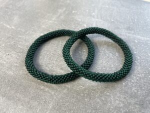 Unikke håndlavet nepal armbånd af glasperler- Som er knyttet perle for perle – Af Nepalesiske Kvinder.  Kvindegrupper i Nepal, Kathmandu Valley, udstyres med glasperler og bomuldsgarn, så de i deres fritid kan håndknytte de smukke perlearmbånd. Hvert armbånd er et unikt resultat af kvindernes håndarbejde og varierer i farvekombinationer og mønstre. De er hæklet med en bomuldssnor. Syntes man at de lidt stramme, kan man vride forsigtigt i dem så de bliver større. syntes man derimod at de er blive lidt for løse, kan man ligge dem i vand. dette gør at bomuldssnoren trækker sig sammen og de bliver mindre igen. Unikke håndlavet nepal armbånd, som er knyttet perle for perle, af nepalesiske kvinder. Vi har mere end 200 forskellige, at vælge i mellem. Så du kan finde de helt rigtige roll on nepal perle armbånd.