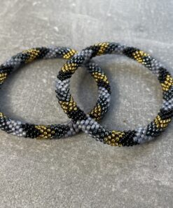 Unikke håndlavet nepal armbånd af glasperler- Som er knyttet perle for perle – Af Nepalesiske Kvinder.  Kvindegrupper i Nepal, Kathmandu Valley, udstyres med glasperler og bomuldsgarn, så de i deres fritid kan håndknytte de smukke perlearmbånd. Hvert armbånd er et unikt resultat af kvindernes håndarbejde og varierer i farvekombinationer og mønstre. De er hæklet med en bomuldssnor. Syntes man at de lidt stramme, kan man vride forsigtigt i dem så de bliver større. syntes man derimod at de er blive lidt for løse, kan man ligge dem i vand. dette gør at bomuldssnoren trækker sig sammen og de bliver mindre igen. Unikke håndlavet nepal armbånd, som er knyttet perle for perle, af nepalesiske kvinder. Vi har mere end 200 forskellige, at vælge i mellem. Så du kan finde de helt rigtige roll on nepal perle armbånd.