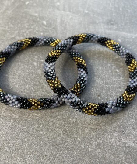 Unikke håndlavet nepal armbånd af glasperler- Som er knyttet perle for perle – Af Nepalesiske Kvinder.  Kvindegrupper i Nepal, Kathmandu Valley, udstyres med glasperler og bomuldsgarn, så de i deres fritid kan håndknytte de smukke perlearmbånd. Hvert armbånd er et unikt resultat af kvindernes håndarbejde og varierer i farvekombinationer og mønstre. De er hæklet med en bomuldssnor. Syntes man at de lidt stramme, kan man vride forsigtigt i dem så de bliver større. syntes man derimod at de er blive lidt for løse, kan man ligge dem i vand. dette gør at bomuldssnoren trækker sig sammen og de bliver mindre igen. Unikke håndlavet nepal armbånd, som er knyttet perle for perle, af nepalesiske kvinder. Vi har mere end 200 forskellige, at vælge i mellem. Så du kan finde de helt rigtige roll on nepal perle armbånd.