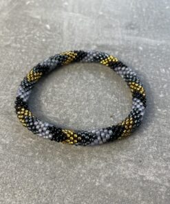 Unikke håndlavet nepal armbånd af glasperler- Som er knyttet perle for perle – Af Nepalesiske Kvinder.  Kvindegrupper i Nepal, Kathmandu Valley, udstyres med glasperler og bomuldsgarn, så de i deres fritid kan håndknytte de smukke perlearmbånd. Hvert armbånd er et unikt resultat af kvindernes håndarbejde og varierer i farvekombinationer og mønstre. De er hæklet med en bomuldssnor. Syntes man at de lidt stramme, kan man vride forsigtigt i dem så de bliver større. syntes man derimod at de er blive lidt for løse, kan man ligge dem i vand. dette gør at bomuldssnoren trækker sig sammen og de bliver mindre igen. Unikke håndlavet nepal armbånd, som er knyttet perle for perle, af nepalesiske kvinder. Vi har mere end 200 forskellige, at vælge i mellem. Så du kan finde de helt rigtige roll on nepal perle armbånd.