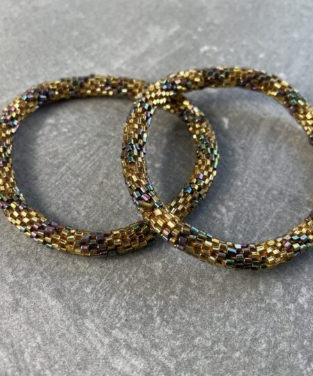 Unikke håndlavet nepal armbånd af glasperler- Som er knyttet perle for perle – Af Nepalesiske Kvinder.  Kvindegrupper i Nepal, Kathmandu Valley, udstyres med glasperler og bomuldsgarn, så de i deres fritid kan håndknytte de smukke perlearmbånd. Hvert armbånd er et unikt resultat af kvindernes håndarbejde og varierer i farvekombinationer og mønstre. De er hæklet med en bomuldssnor. Syntes man at de lidt stramme, kan man vride forsigtigt i dem så de bliver større. syntes man derimod at de er blive lidt for løse, kan man ligge dem i vand. dette gør at bomuldssnoren trækker sig sammen og de bliver mindre igen. Unikke håndlavet nepal armbånd, som er knyttet perle for perle, af nepalesiske kvinder. Vi har mere end 200 forskellige, at vælge i mellem. Så du kan finde de helt rigtige roll on nepal perle armbånd.