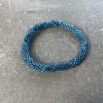Unikke håndlavet nepal armbånd af glasperler- Som er knyttet perle for perle – Af Nepalesiske Kvinder.  Kvindegrupper i Nepal, Kathmandu Valley, udstyres med glasperler og bomuldsgarn, så de i deres fritid kan håndknytte de smukke perlearmbånd. Hvert armbånd er et unikt resultat af kvindernes håndarbejde og varierer i farvekombinationer og mønstre. De er hæklet med en bomuldssnor. Syntes man at de lidt stramme, kan man vride forsigtigt i dem så de bliver større. syntes man derimod at de er blive lidt for løse, kan man ligge dem i vand. dette gør at bomuldssnoren trækker sig sammen og de bliver mindre igen. Unikke håndlavet nepal armbånd, som er knyttet perle for perle, af nepalesiske kvinder. Vi har mere end 200 forskellige, at vælge i mellem. Så du kan finde de helt rigtige roll on nepal perle armbånd.