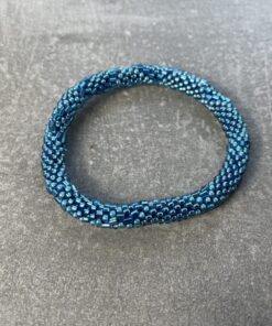 Unikke håndlavet nepal armbånd af glasperler- Som er knyttet perle for perle – Af Nepalesiske Kvinder.  Kvindegrupper i Nepal, Kathmandu Valley, udstyres med glasperler og bomuldsgarn, så de i deres fritid kan håndknytte de smukke perlearmbånd. Hvert armbånd er et unikt resultat af kvindernes håndarbejde og varierer i farvekombinationer og mønstre. De er hæklet med en bomuldssnor. Syntes man at de lidt stramme, kan man vride forsigtigt i dem så de bliver større. syntes man derimod at de er blive lidt for løse, kan man ligge dem i vand. dette gør at bomuldssnoren trækker sig sammen og de bliver mindre igen. Unikke håndlavet nepal armbånd, som er knyttet perle for perle, af nepalesiske kvinder. Vi har mere end 200 forskellige, at vælge i mellem. Så du kan finde de helt rigtige roll on nepal perle armbånd.