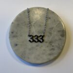 Halskæde med engletal 333 i guld eller sølv. Symbol på vækst, støtte og kreativitet. Spirituelt smykke i 45 cm længde med smukt, enkelt design.